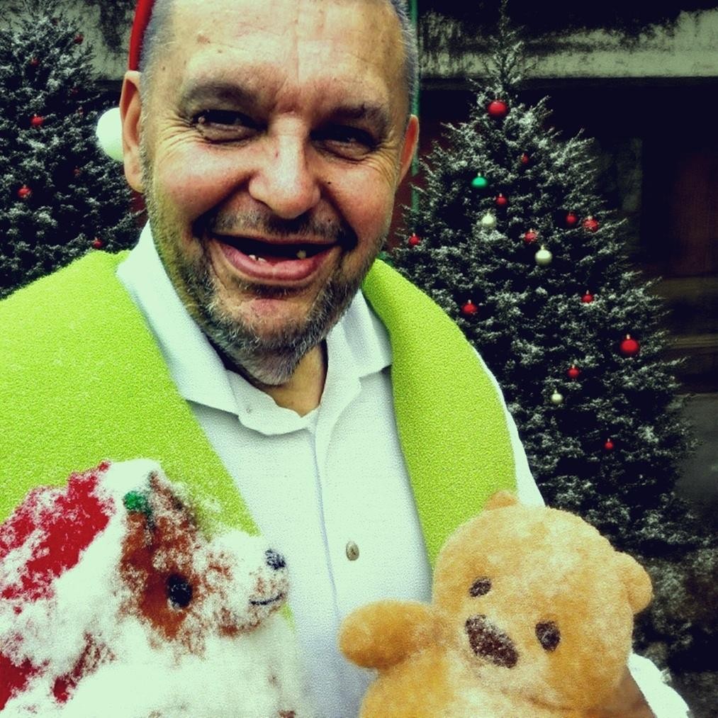 Krzysztof Kononowicz podczas publicznego wystąpienia, otoczony ludźmi, oddający atmosferę jego medialnej popularności i kontrowersji.