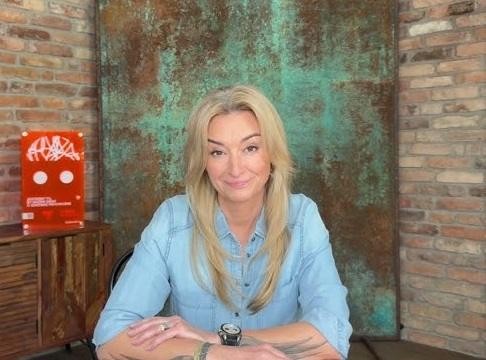 Martyna Wojciechowska podczas podróży, w otoczeniu egzotycznej kultury lub natury, ukazująca jej zaangażowanie w poznawanie świata i ludzi.