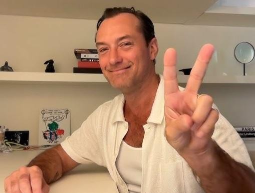 Jude Law w otoczeniu rodziny, w ciepłej, domowej atmosferze, symbolizującej jego życie prywatne.