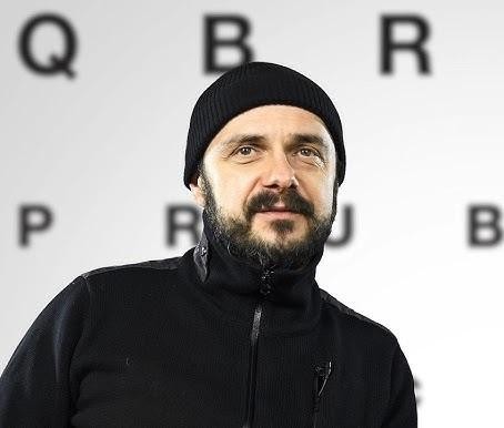 Arkadiusz Jakubik, polski aktor i reżyser, w dynamicznym ujęciu, odzwierciedlającym jego wszechstronność artystyczną i intensywność twórczą.