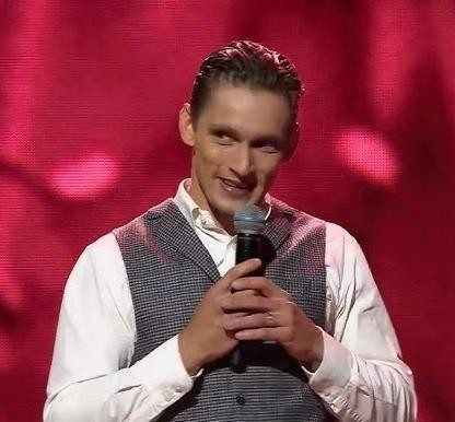 Filip Gurłacz w naturalnej pozie, być może na planie lub podczas wydarzenia, ukazujący jego autentyczność i ekspresję.