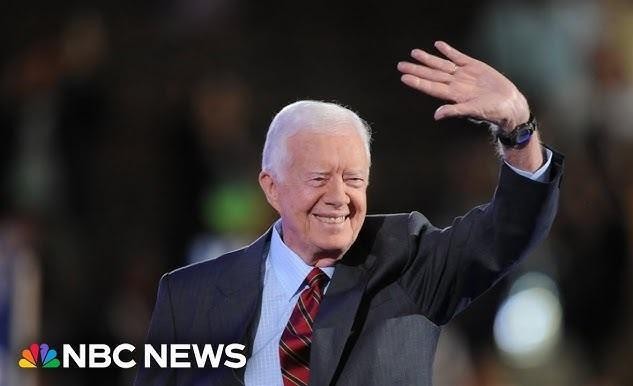 Jimmy Carter aktywnie uczestniczący w budowie domu dla Habitat for Humanity, symbolizujący jego poświęcenie dla działalności humanitarnej po prezydenturze.