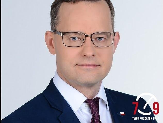 Scena z debaty politycznej lub obrad parlamentarnych, symbolizująca zaangażowanie w życie publiczne.