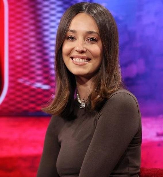 Izabella Krzan na planie programu telewizyjnego, uśmiechnięta i pełna energii, w otoczeniu studyjnym.