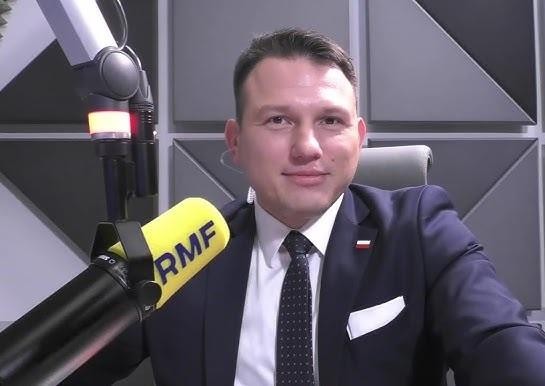 Sławomir Mentzen podczas wystąpienia publicznego, z gestykulacją podkreślającą jego charyzmę i zdolności oratorskie.