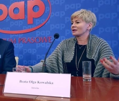 Beata Olga Kowalska w dynamicznej scenie teatralnej lub telewizyjnej, prezentująca swój talent aktorski.